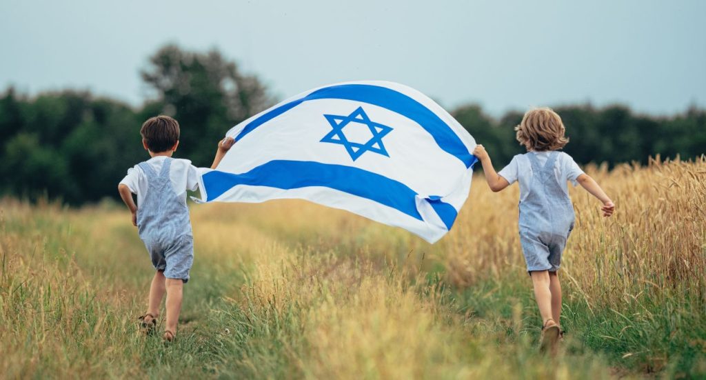 ילדים רצים עם דגל בשדה